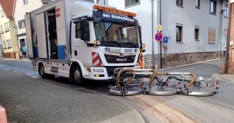 Ölspurreinigung in einer engen Straße in Würzburg